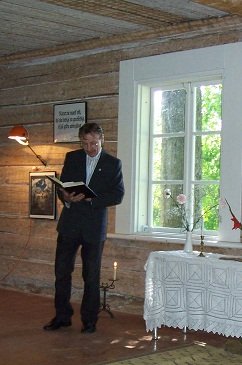 Arnis Dāmis lasa evaņģeliju pie altāra saiešanas namā